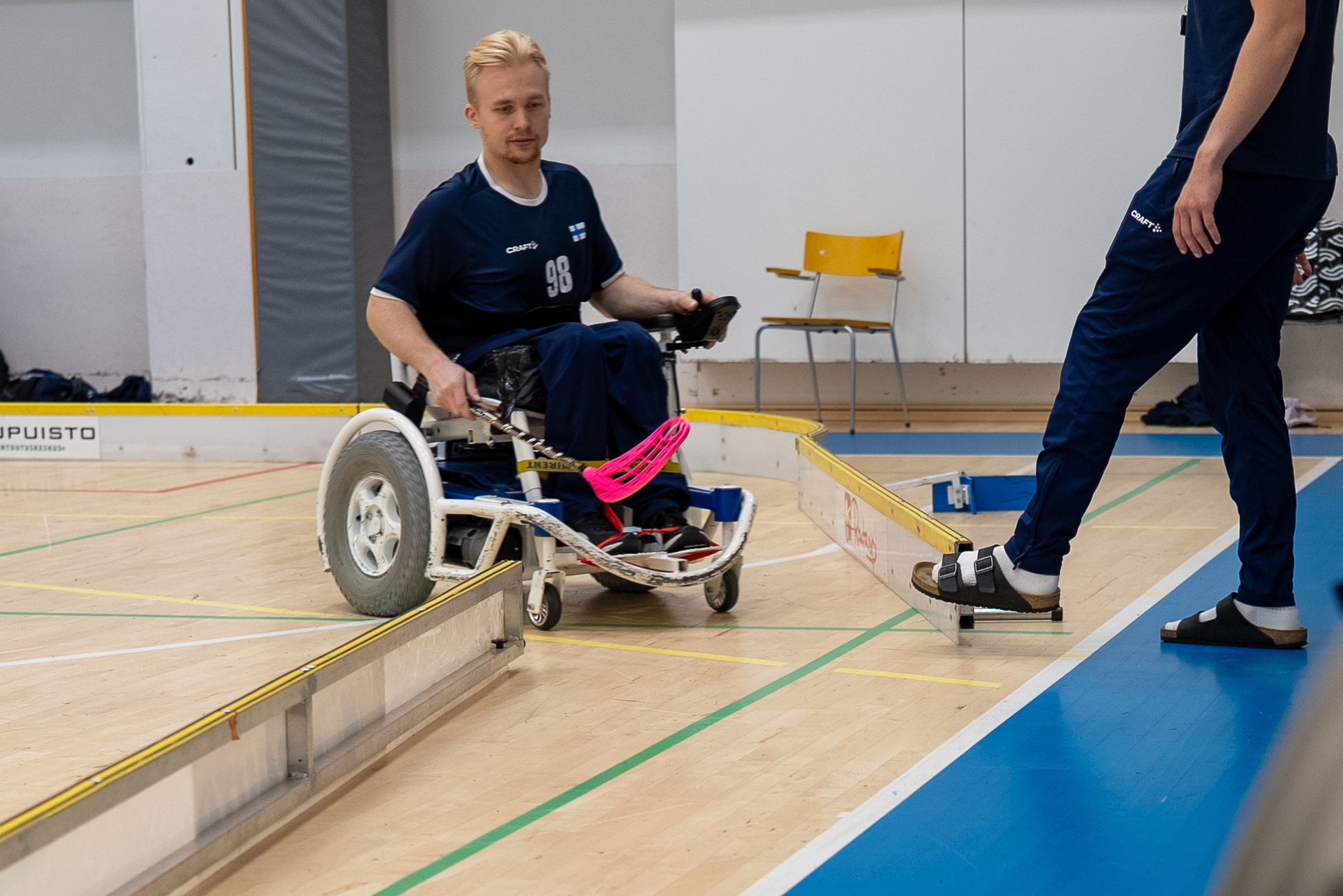 Kuvassa henkilö tulee sähköpyörätuolisähköpyörätuolilla vaihtoaitioon avatun laidan aukosta.